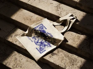 Tote bag personalizado impresso pela AJNET com design artístico em azul, exemplo de merchandising de alta qualidade.